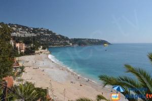 a view of a beach with people in the water at Le Golfe bleu in Roquebrune-Cap-Martin