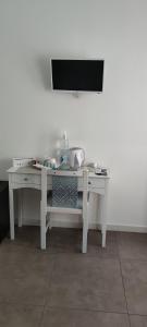 Elle comprend un bureau blanc et une télévision murale. dans l'établissement B-KARALIS DI ENRICO TUPPUTI, à Cagliari