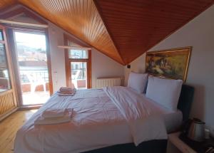 a large white bed in a room with windows at Buyukada Cinar Hotel in Buyukada