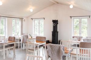 a dining room with tables and chairs and windows at Kåseberga Gårdshotell & Spa in Kåseberga