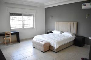 亞喀巴的住宿－Aqaba Escape 1，一间卧室配有一张大床和一张书桌