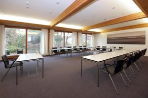 einen Konferenzraum mit Tischen, Stühlen und Fenstern in der Unterkunft Seehotel Schiff in Mannenbach