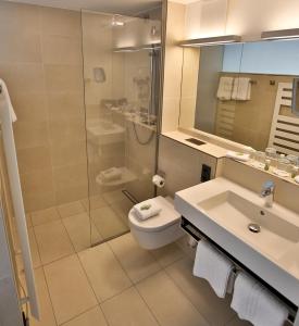 La salle de bains est pourvue de toilettes, d'un lavabo et d'une douche. dans l'établissement Wo der Hahn kräht, à Flein