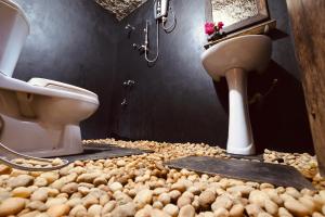 a bathroom with a toilet and a sink and a pile of balls at Private Organic House in Udawalawe