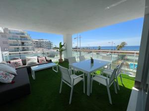 een woonkamer met een tafel en stoelen en de oceaan bij Vista Azul Duna 2 by Spain2home in Torrox