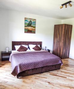 1 dormitorio con 1 cama grande y edredón morado en Noclegi Kalniczka en Tarnawa Dolna