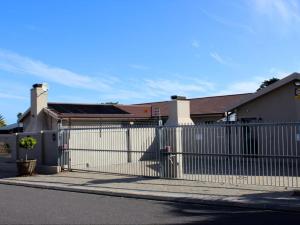 a white fence in front of a house at Two Oceans Stay in Cape Town
