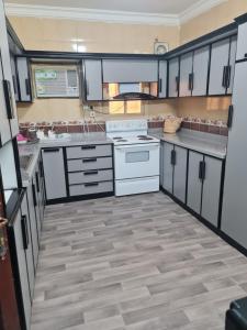 a kitchen with white appliances and wooden floors at شقة عائلية -ليست فندقية- 8 دقائق بالسيارة للحرم أو قباء - in Medina