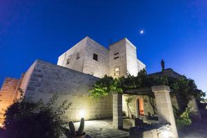 a large white building with a moon in the sky at Hotel Delle Cave in Favignana