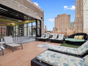 a rooftop patio with couches and chairs on a building at Lavish Condo steps to Great All American Ball Park 502 in Cincinnati