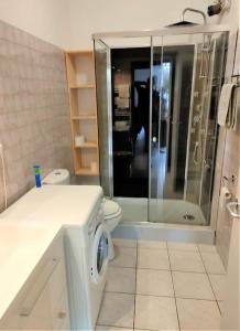 a white bathroom with a shower and a toilet at Le petit Goudarguais in Goudargues