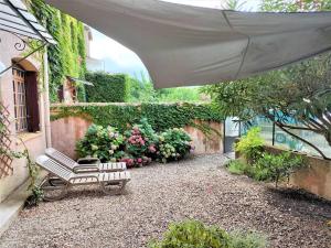 a patio with two chairs under an umbrella at Le petit Goudarguais in Goudargues