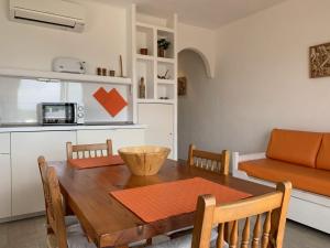 eine Küche und ein Esszimmer mit einem Tisch und einem Sofa in der Unterkunft Copacabana 21 in Es Pujols