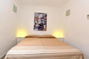 Bett in einem Zimmer mit zwei eingeschalteten Lampen in der Unterkunft Copacabana 21 in Es Pujols