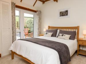 um quarto com uma cama grande e uma janela grande em Little Orchard em Newton Abbot
