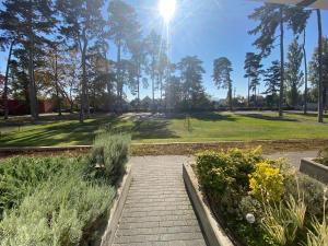 a walkway leading to a park with trees and grass at BL LAKESIDE APARTMAN in Balatonlelle