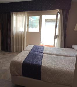 um quarto com uma cama com um cobertor azul e branco em Castilla Guerrero em Málaga