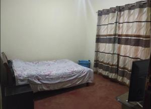 Nairagie Ngare的住宿－2 br own compound furnished hse，一间带床和窗帘的小卧室