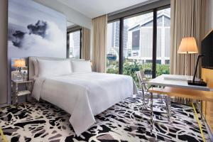 a bedroom with a white bed and a large window at JW Marriott Hotel Singapore South Beach in Singapore