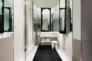 a bathroom with a white tub and a sink and mirrors at JW Marriott Hotel Singapore South Beach in Singapore