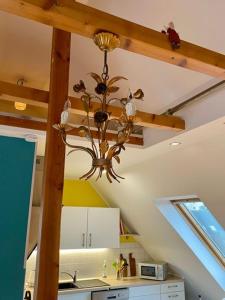 una cucina con lampadario pendente appeso a un soffitto di Schubert & Schubert - Ihr außergewöhnliches Zuhause auf Zeit a Hilden