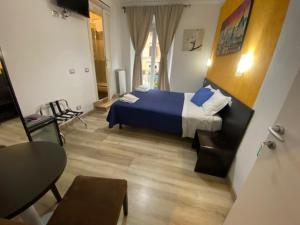 ローマにあるB&B A Home in Romeのベッドルーム1室(ベッド1台、テーブル、椅子付)