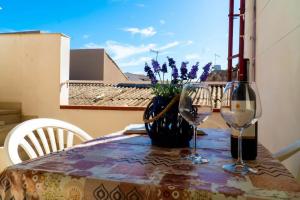 a table with two wine glasses on a balcony at Casa Charm RosaApartmentsOrtigia in Syracuse