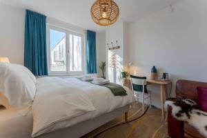 a bedroom with a bed and a desk and a window at Geulzicht Hotel in Schin op Geul