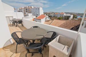 un patio con tavolo e sedie sul balcone. di New Village Guest House a Lagos