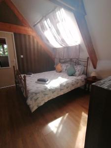 een klein bed in een kamer met een raam bij le petit secret in Saint-Hilaire