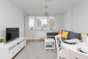 ein Wohnzimmer mit einem Sofa und einem Tisch in der Unterkunft Apartments Golden Warsaw by Renters in Warschau