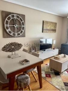 a living room with a large clock on the wall at APARTAMENTO FELECHOSA in Felechosa