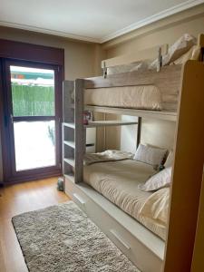 a bedroom with two bunk beds and a rug at APARTAMENTO FELECHOSA in Felechosa