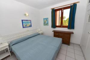 Un dormitorio con una cama azul y una ventana en Copacabana 27, en Es Pujols