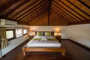 勒吉安Three Brothers Bungalows & Villas的房间里有一张大床的卧室