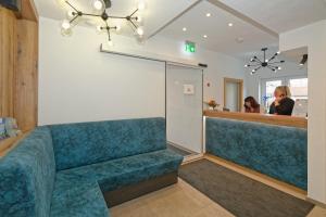 a waiting room with a blue couch and a counter at Hotel 17 Seen in Eggstätt