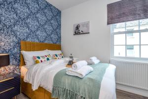 a bedroom with a bed with towels on a table at The Cotswold Woodland in Cheltenham