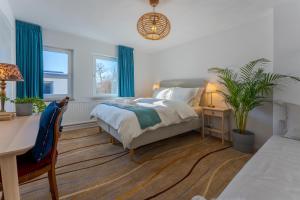 a bedroom with a bed with blue curtains and a desk at Geulzicht Hotel in Schin op Geul