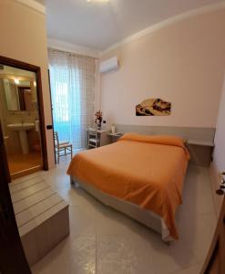 a bedroom with an orange bed and a bathroom at B&B Santa Rosa in Salerno