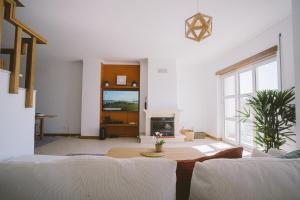 a living room with a table and a fireplace at Best Houses 52 - Baleal Surfside in Ferrel
