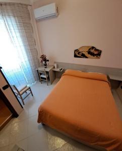 1 dormitorio con cama de color naranja y mesa en B&B Santa Rosa, en Salerno