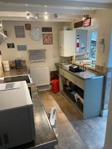 een keuken met een wastafel en een aanrecht bij Bryn Goleu, Mersey Street, Borth-y-Gest in Porthmadog