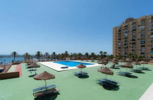 um resort com piscina, cadeiras e guarda-sóis em Sur Suites Palmeras 10 em Fuengirola