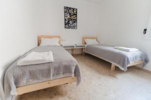 a bedroom with two beds and a table at ARISTO Machne Yehuda boutique apartments in Jerusalem