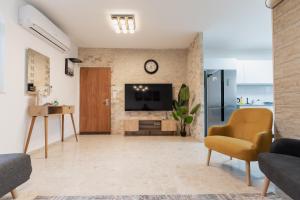 a living room with a tv on a brick wall at ARISTO Machne Yehuda boutique apartments in Jerusalem