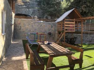 un patio con una mesa de madera y un parque infantil en DIAMOND Stone Wooden Guest House, en Khandria