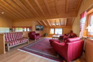 ein Wohnzimmer mit roten Möbeln und einer Holzdecke in der Unterkunft Ferienwohnungen Weiler in Oberstdorf