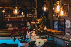 a bar with flowers on a counter with lights at Geulzicht Hotel in Schin op Geul