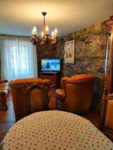 ein Wohnzimmer mit Tisch und Stühlen und einem Fernseher in der Unterkunft Casa Brisas del Mar in Cabana de Bergantiños