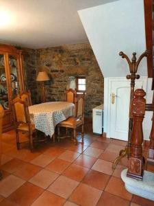 uma sala de jantar com mesa e cadeiras e uma parede de pedra em Casa Brisas del Mar em Cabana de Bergantiños